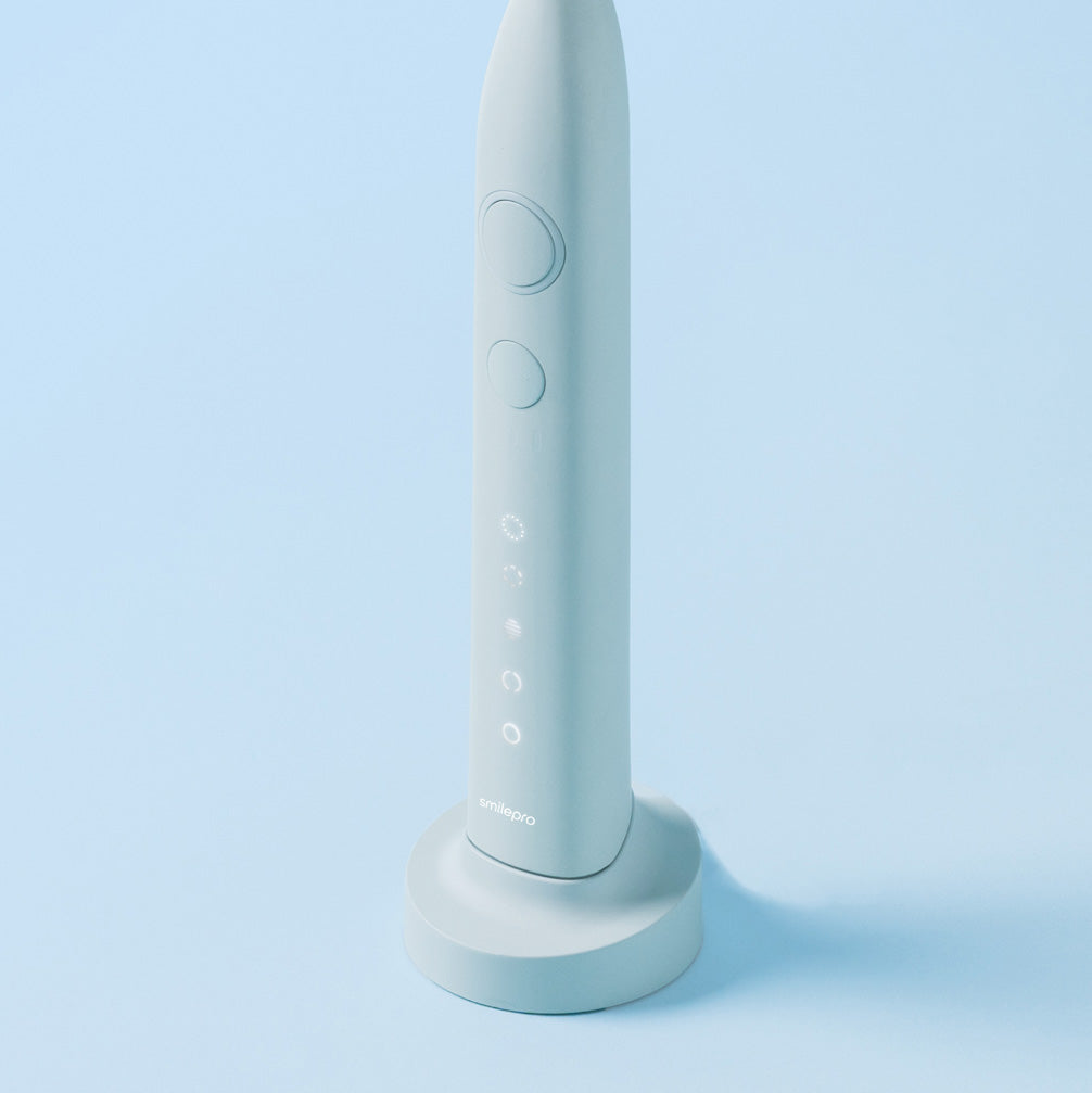 SmilePro Sonic Toothbrush in Soft Mint on its charging base